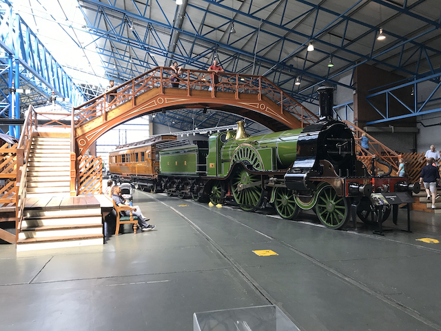Opal standing on a bridge over a green locomotive in the UK National Rail Museum